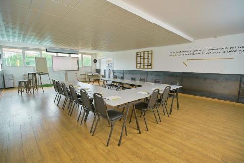 a classroom with a table and chairs and a whiteboard at Sporting House Hôtel in Toulouse