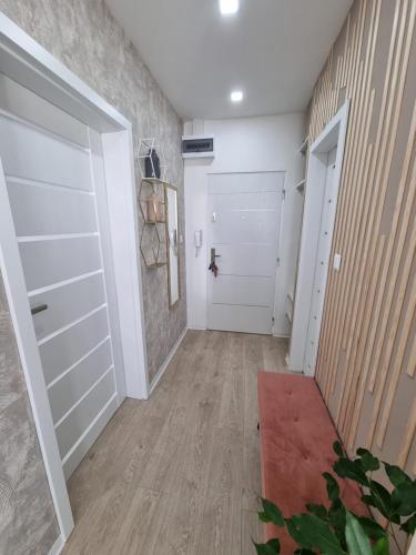 a hallway with a white garage door and a red rug at ALPHA Apartman Malacky in Malacky