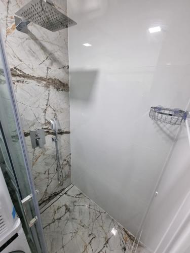 a bathroom with a shower with a marble wall at ALPHA Apartman Malacky in Malacky