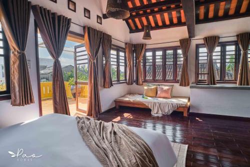um quarto com uma cama e uma grande janela em Pao Homes - An Hai Villa, Family-Friendly Villa with Pool em Hoi An