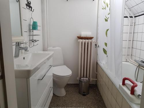 a white bathroom with a toilet and a sink at Bed & Kitchen i Højer in Højer