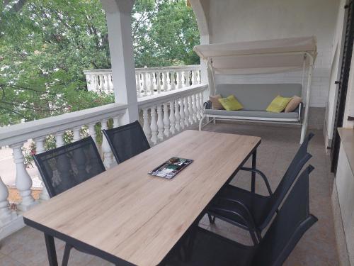 a wooden table and chairs on a porch at Apartment Rupena in Klimno