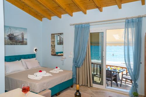 a bedroom with a bed with a view of the ocean at Elena's Seaside Apartments & Studios in Agios Gordios