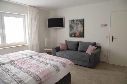 a bedroom with a bed and a couch at Ferienwohnung Hankeln in Winterberg
