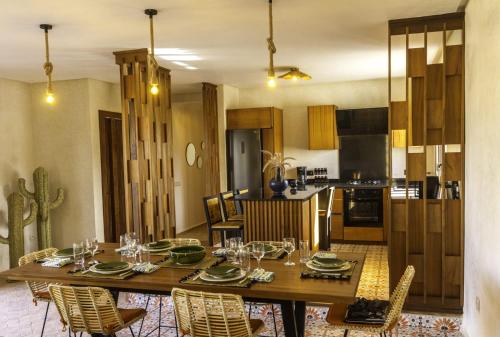 a kitchen and dining room with a wooden table and chairs at Villa Ehzzara piscine chauffée in Essaouira