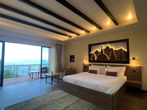 a bedroom with a large bed and a large window at Dhulikhel Lodge Resort in Dhulikhel
