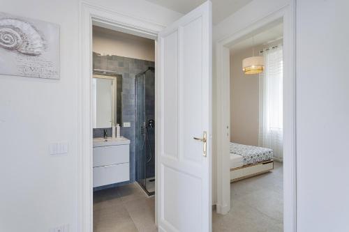 ein weißes Badezimmer mit einem Waschbecken und einem Spiegel in der Unterkunft In Fondo al Mar by Wonderful Italy in Santa Margherita Ligure