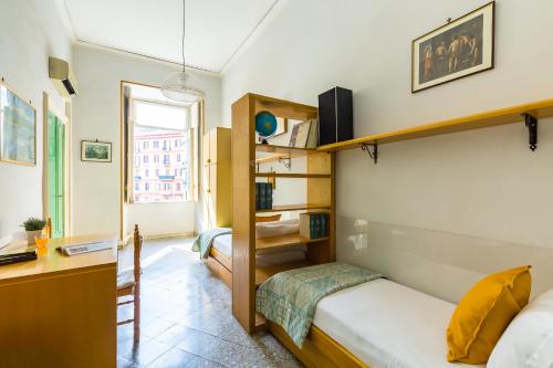 a small bedroom with a bed and a desk and a window at Rettifilo Family Apartment by Wonderful Italy in Naples