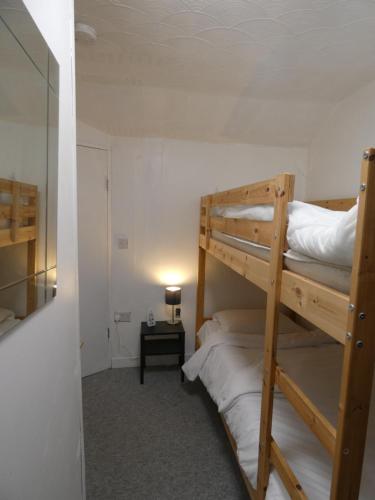 a room with two bunk beds and a lamp at Bridge Street En Suite Rooms in Merthyr Tydfil