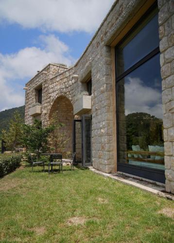 a stone house with a window and a bench at Bkerzay in Baakleen