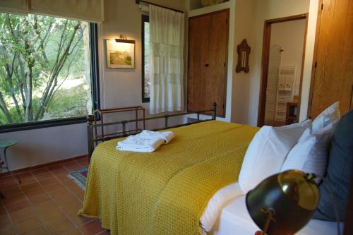 a bedroom with a bed with a yellow blanket and a window at Bkerzay in Baakleen