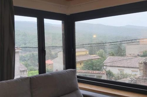 a large window with a couch in front of it at Dúplex Sant Martí in Ager