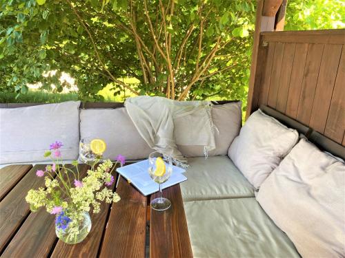 a couch with a table and flowers on it at Mazury Glamping Kruklanki Polana Życzeń in Kruklanki