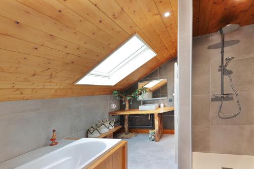 uma casa de banho com uma banheira e uma clarabóia em Granit'Home em Gérardmer
