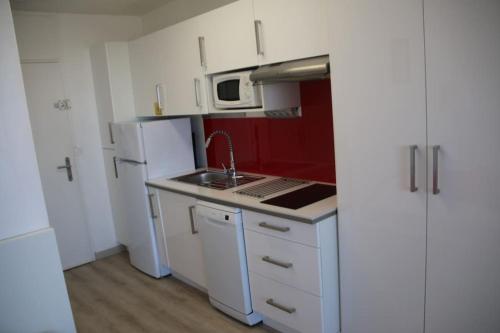 une petite cuisine avec un évier et un réfrigérateur dans l'établissement Studio 99, Héliopolis E au village naturiste, au Cap d'Agde