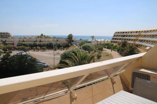 d'un balcon avec vue sur la plage et les bâtiments. dans l'établissement Studio 99, Héliopolis E au village naturiste, au Cap d'Agde