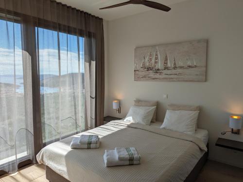 ein Schlafzimmer mit einem Bett und einem großen Fenster mit Segelbooten in der Unterkunft Villa Vinisce View in Vinišće