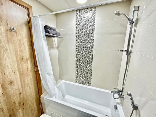a bathroom with a shower and a tub and a toilet at Dubai Marina Continental tower in Dubai