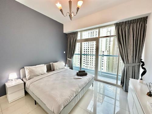 a bedroom with a large bed and a large window at Dubai Marina Continental tower in Dubai