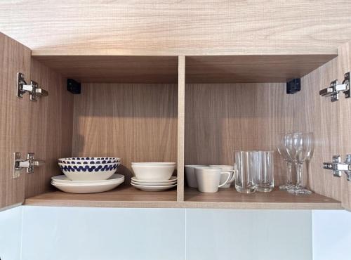 a cupboard with bowls and dishes on a shelf at Deluxe Pool View La Casita Hua Hin Managed By Asiabb in Hua Hin