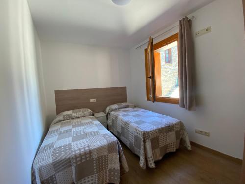 a bedroom with two beds and a window at Era de Caçador in Llavorsí