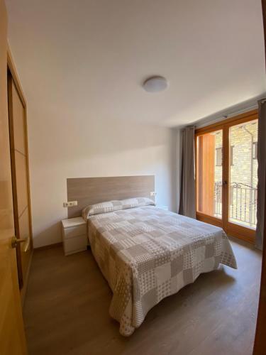 een slaapkamer met een bed en een groot raam bij Era de Caçador in Llavorsí