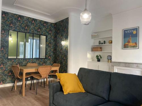 un salon avec un canapé bleu et une table dans l'établissement Superbe Appartement Cosy 2 Min Métro Joliette, à Marseille