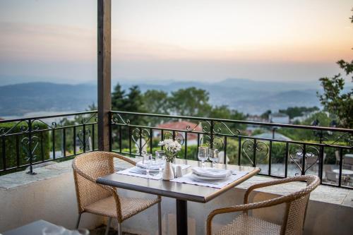 a table and chairs on a balcony with a view at Portaria Hotel in Portariá