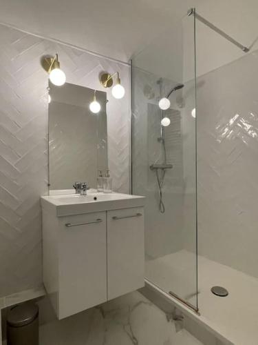une salle de bain blanche avec un lavabo et une douche dans l'établissement Superbe Appartement Cosy 2 Min Métro Joliette, à Marseille