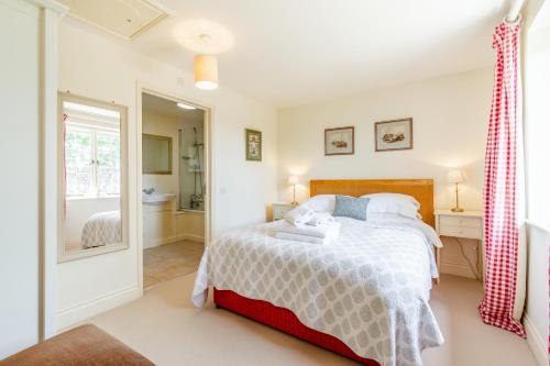 a bedroom with a bed and a bathroom at Hop Cottage in East Dean