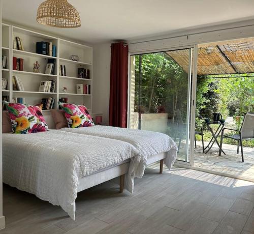 une chambre avec un lit et une porte coulissante en verre dans l'établissement Villa provençale Les Figuiers 3 étoiles - Piscine chauffée, à Lorgues