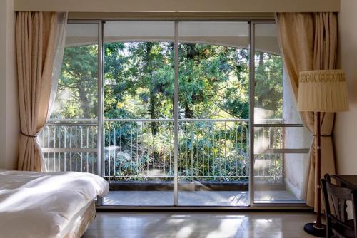 a bedroom with a large window with a view at B&B Retreat志摩 in Shima