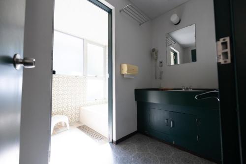 bagno con lavandino, vasca e specchio di B&B Retreat志摩 a Shima