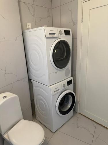 a bathroom with a washing machine and a toilet at Kulladal Malmö in Malmö