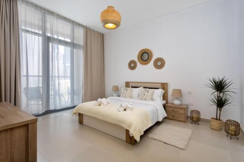 un dormitorio con una cama con dos animales de peluche en Waves Holiday Home - Chic Apartment With Dubai Skyline Views, en Dubái