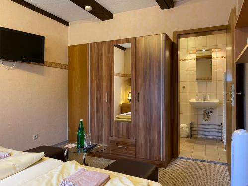 Dieses Hotelzimmer verfügt über ein Bad mit einem WC und einem Waschbecken. in der Unterkunft RATAGS Kunsthandwerkerhaus in Langenwolmsdorf