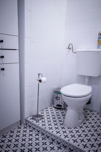 a bathroom with a toilet and a black and white tile floor at Centergom in Esztergom