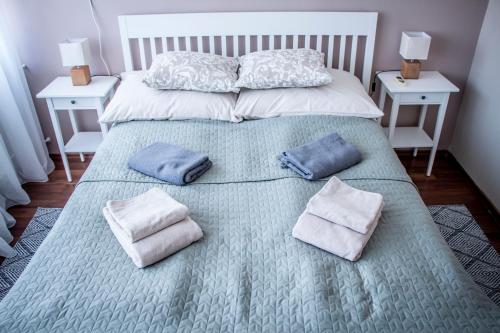 a bed with two pillows on it with two tables at Centergom in Esztergom