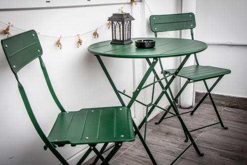 a green table with two chairs and a lamp at Centergom in Esztergom