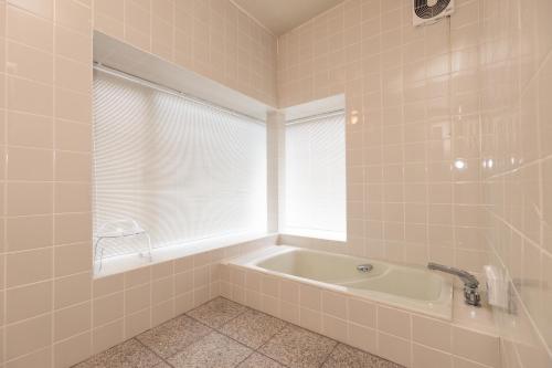 baño con bañera y ventana en オーシャンビュー　秋田の夕日・海の見える別荘セントキルダ　一棟貸し, en Nikaho