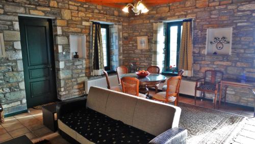 a living room with a table and a stone wall at Pelion Goddess Villas in Agios Georgios Nilias