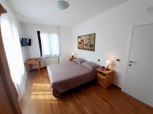 una camera da letto con un letto in una stanza bianca di LOCANDA DAL BARBA a Villa Lagarina