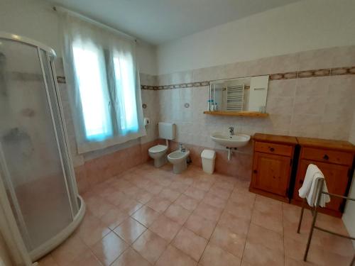 un bagno con due WC, una doccia e un lavandino di LOCANDA DAL BARBA a Villa Lagarina