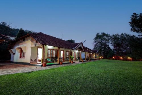 a house with a lawn in front of it at Prakruthi Home Stay in Sollebail