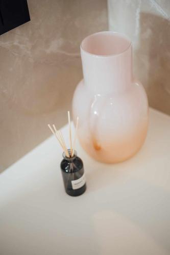 a white vase with chopsticks in it on a table at Thirsty Dog Urban Port Studios in Igoumenitsa