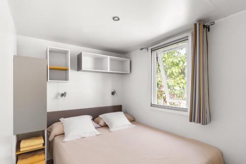 a bedroom with a bed and a window at Camping El Pinar in Blanes