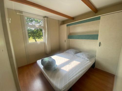 a small bedroom with a bed and a window at Camping familial les chalets d'Uza in Uza