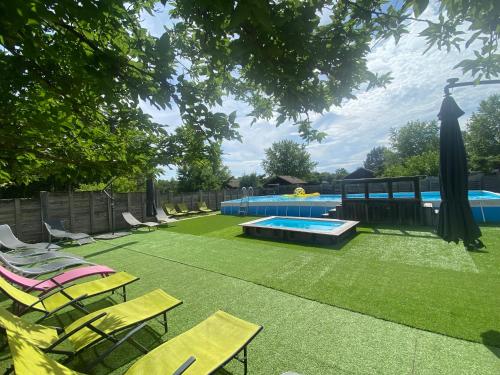 a backyard with chairs and a swimming pool and a tree at Camping familial les chalets d'Uza in Uza