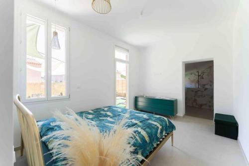 a bedroom with a bed with a blue and white blanket at Villa 6 pers 5 min Marseille in Marseille