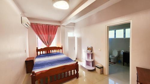 a bedroom with a wooden bed in a room with a window at Ocean Heart Hotel in Sigatoka